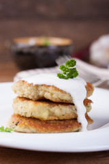 Fried potato pancakes with oatmeal and basil on a white ceramic plate.
