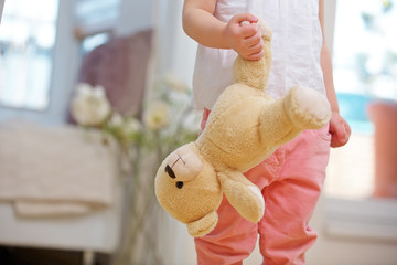 Kind trägt Teddybär am Bein - obrazy, fototapety, plakaty