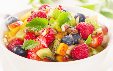 Bowl of  healthy fresh fruit salad with honey.
