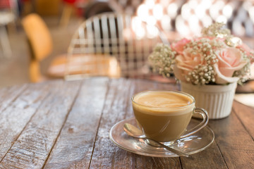 hot coffee and bouquet of flower on grunge wood table
