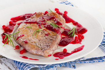 Turkey breast with cranberry sauce on white plate.
