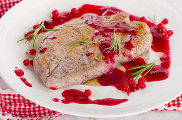 Turkey breast with cranberry sauce on a white plate.