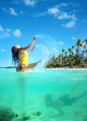 Beautiful young woman in bikini on the sunny tropical beach rela
