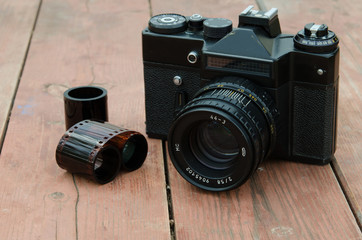Classic camera zenith with the film on the wooden background