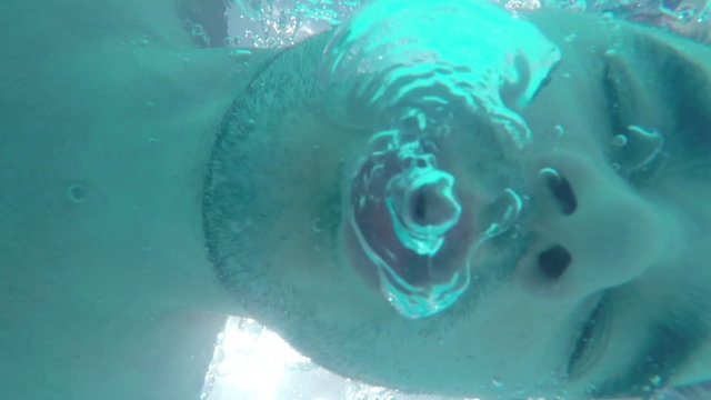 Man breathing out air bubbles underwater slow motion