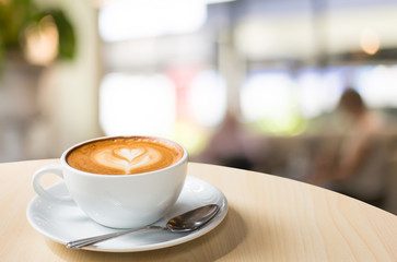 Hot art Latte Coffee in a cup on wooden table and Coffee shop bl