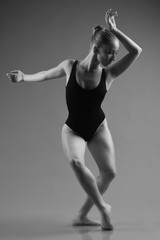 Modern ballet dancer posing on dark background