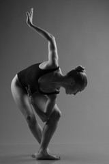 Modern ballet dancer posing on dark background