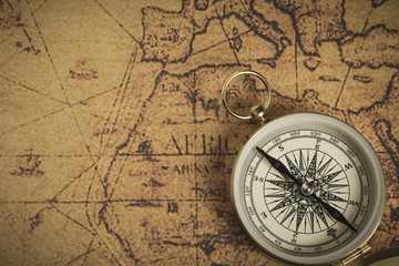 Obraz na płótnie Canvas Golden compass on a vintage map