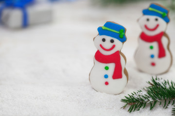 Christmas gingerbread snowman cookies on a bed of snow with copy space