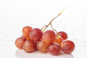 bunch of grapes in white base with water droplets wet