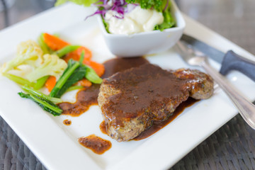 A dish of meat steak covered with herb