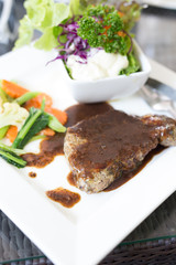 A dish of meat steak covered with herb
