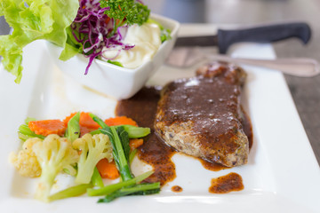 A dish of meat steak covered with herb