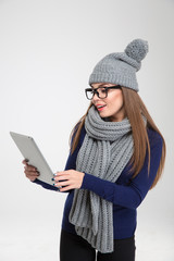 Woman in winter cloth using tablet computer