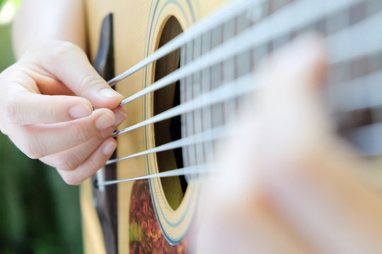 Close up image of Musicians are playing on his acoustic bass guitars. 