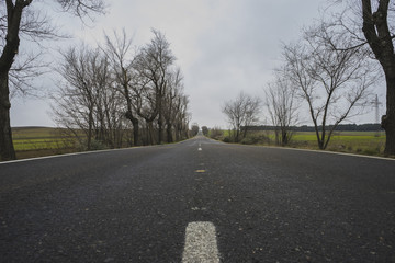 lonely road, desolate landscape with ruins on a cloudy day