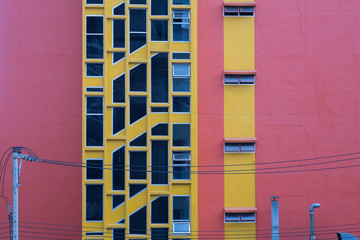 vivid red and yellow building with electric cable