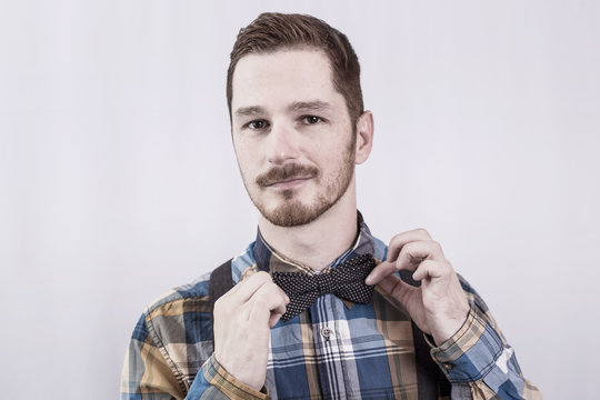 Redhead man holding his bow tie 