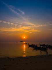 Beautiful Sunrise and silhouette local fishing boats on sea at t