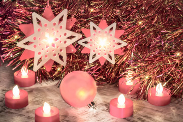 Christmas composition with ball and candles in pink