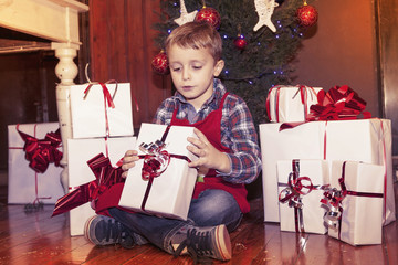 lovely little boy opens a christmas gifts