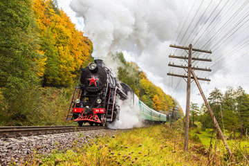 Retro steam train approaches mountains