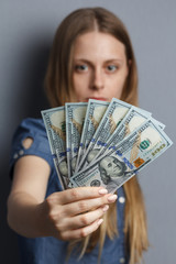 Fan of 100 dollar banknotes in woman hands