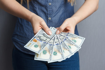 Fan of 100 dollar banknotes in woman hands