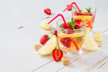 Strawberry lemonade ingredients with mint, white wood background