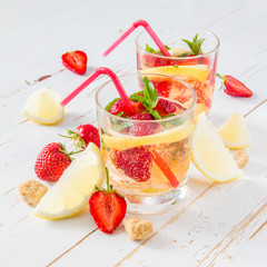 Strawberry lemonade ingredients with mint, white wood background