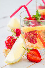Strawberry lemonade ingredients with mint, white wood background