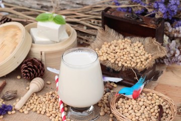 Soy milk and soybeans on wood background.