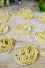 fresh homemade pasta machine pasta, basil, tomatoes on a wooden