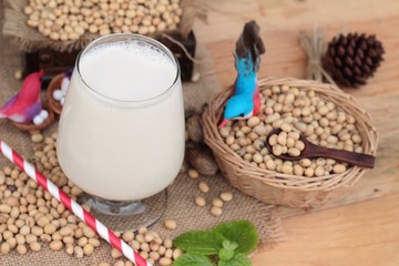 Soy milk and soybeans on wood background.