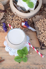 Fototapeta na wymiar Soy milk and soybeans on wood background.