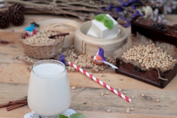 Soy milk and soybeans on wood background.