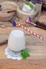 Soy milk and soybeans on wood background.