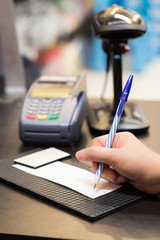 Consumer signing on a sale transaction receipt with Credit Card