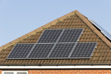 Solar panels for generating electricity on two aspects of the roof of a house in England.