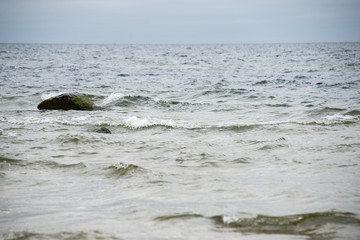 Rocky autumn beach with waves crashing on the rocks