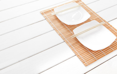 plates with bamboo sticks on a white table