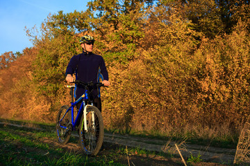 Obraz premium young adult cyclist riding mountain bike in the countryside