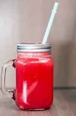 Watermelon smoothie in a mason jar with tube