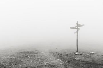 wooden signpost in the fog