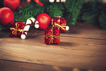 Christmas gift box with red ribbon on dark wooden background in vintage style