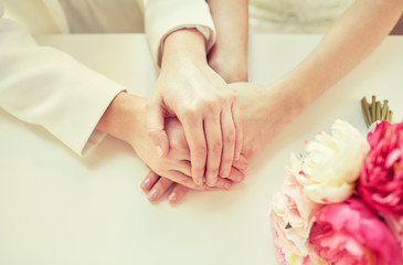 Obraz na płótnie Canvas close up of happy married lesbian couple hands