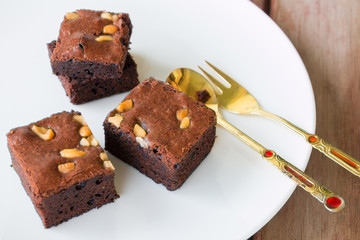 brownies and golden spoon with cup of coffee on table