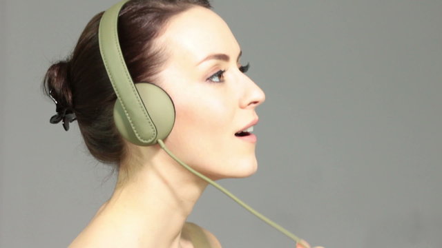 Attractive young woman listening to music through headphones