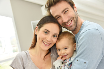Portrait of happy parents holding baby girl